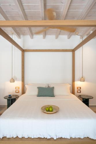 a bed with a bowl of fruit on it at Nisomar Suites in Symi