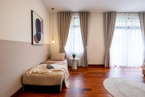 a bedroom with two beds and two large windows at Bungalow Putrajaya 15pax w Private Pool Gathering in Putrajaya