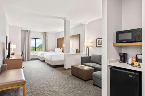 a hotel room with a bed and a living room at Comfort Suites Stuart-Hutchinson Island in Stuart