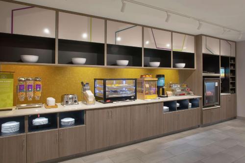 a restaurant kitchen with a counter with dishes and a tv at Home2 Suites By Hilton Little Rock Midtown Medical Center in Little Rock