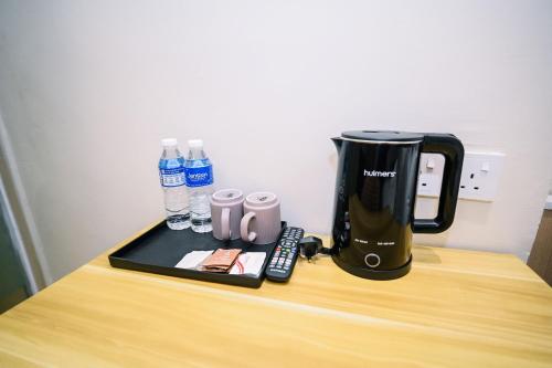a coffeemaker sitting on top of a wooden table at Swing & Pillows - Times Square, Bukit Bintang in Kuala Lumpur