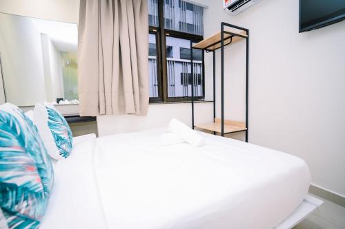 a white bed in a room with a window at Swing & Pillows - Times Square, Bukit Bintang in Kuala Lumpur