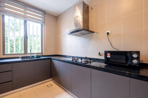 a kitchen with a microwave and a counter top at Bungalow Putrajaya 15pax w Private Pool Gathering in Putrajaya