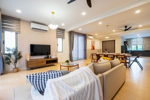 a living room with a couch and a dining room at Bungalow Putrajaya 15pax w Private Pool Gathering in Putrajaya