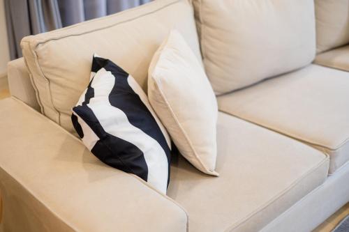 a tie sitting on a couch with two pillows at Bungalow Putrajaya 15pax w Private Pool Gathering in Putrajaya