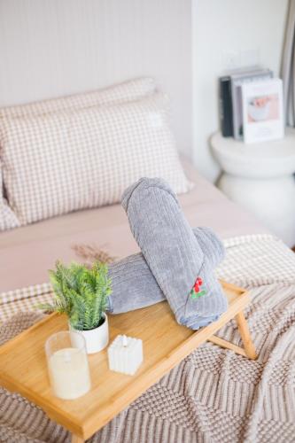 a wooden tray with two mittens and a plant on a bed at Bungalow Putrajaya 15pax w Private Pool Gathering in Putrajaya