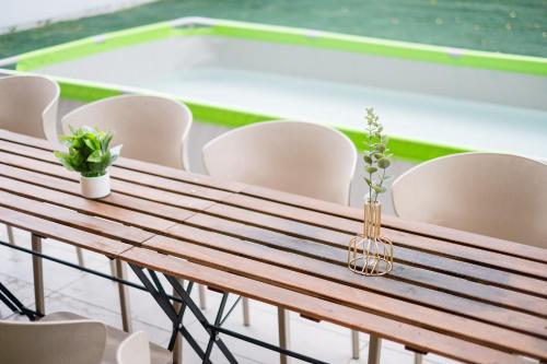 a wooden table with chairs and a swimming pool at Bungalow Putrajaya 15pax w Private Pool Gathering in Putrajaya