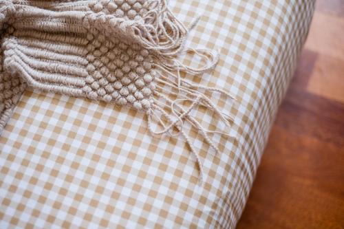 a close up of a couch with a checkered cushion at Bungalow Putrajaya 15pax w Private Pool Gathering in Putrajaya