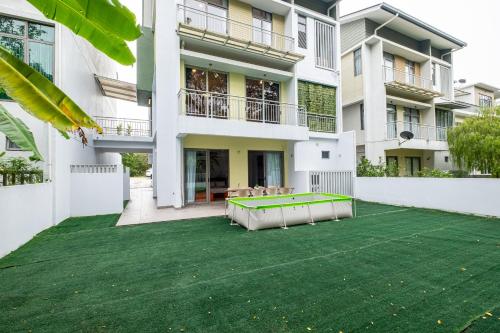a backyard with a green lawn in front of a building at Bungalow Putrajaya 15pax w Private Pool Gathering in Putrajaya