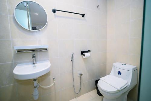 a bathroom with a toilet and a sink and a mirror at Swing & Pillows - Times Square, Bukit Bintang in Kuala Lumpur