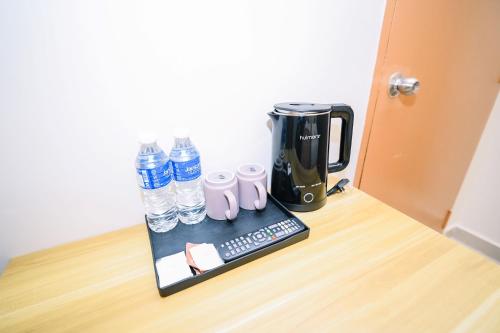 a coffee maker and water bottles on a table at Swing & Pillows - Times Square, Bukit Bintang in Kuala Lumpur