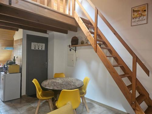 une salle à manger avec une table et des chaises jaunes dans l'établissement Les mascottes, à Luz-Saint-Sauveur