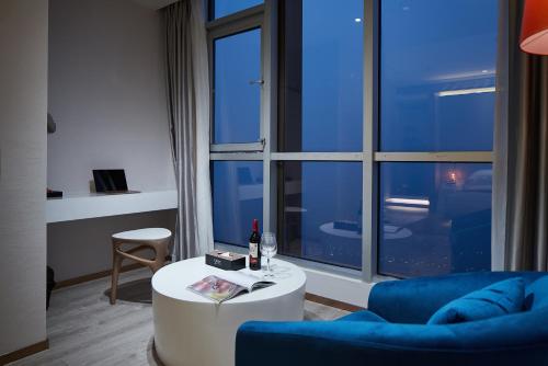 a living room with a blue couch and a table at m58 Sky Sunset Hotel in Chongqing