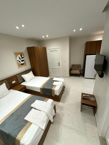 a hotel room with two beds and a flat screen tv at October Square in 6th Of October