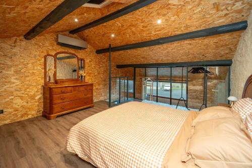 a bedroom with a bed and a mirror and a dresser at Le Mas de l Olivier in Poulan-Pouzols