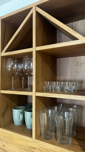 a wooden cabinet filled with glasses and bowls at Bela Reka C308 in Brzeće