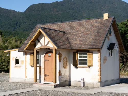a small white house with a brown roof at Cottage Morinokokage in Yakushima