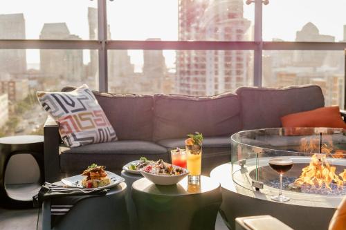 a living room with a couch and a table with food at Hotel Indigo San Diego - Gaslamp Quarter by IHG in San Diego