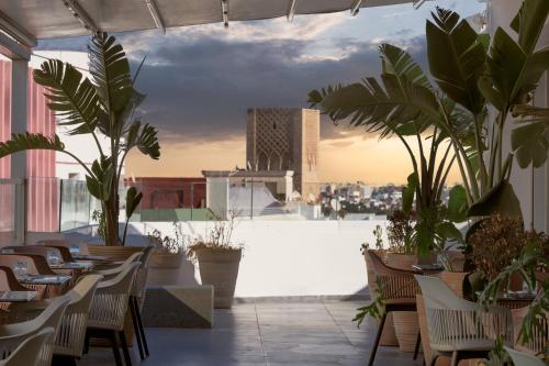 un restaurant avec des chaises et des plantes sur le toit dans l'établissement Rihab Hotel, à Rabat