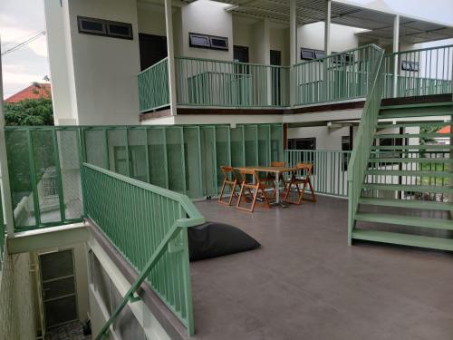 a balcony with a table and chairs in a building at HŌM Coliving Bali in Kerobokan
