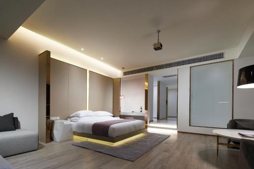a bedroom with a king sized bed and a couch at m58 Sky Sunset Hotel in Chongqing