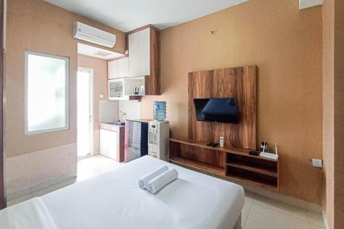 um quarto de hotel com uma cama e uma TV em Classic Studio at Student Castle Yogyakarta Apartment By Travelio em Seturan