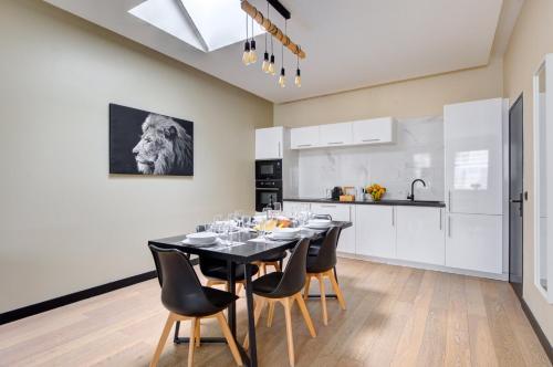 une cuisine et une salle à manger avec une table et des chaises noires dans l'établissement Bluestay 60 - Superbe appartement à Paris, à Paris