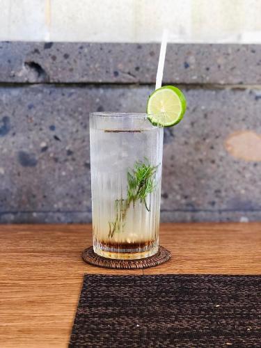 a drink with a lime slice in it on a table at Doni House & Villas in Ubud