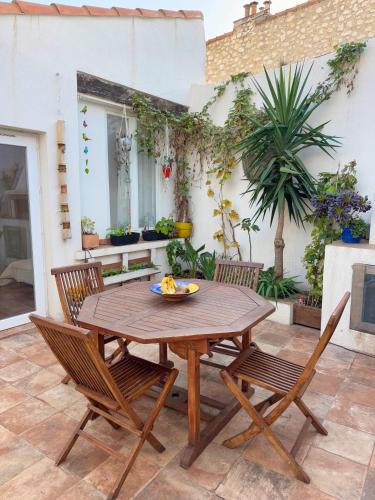 une table et des chaises en bois sur une terrasse dans l'établissement Maison Cozy, Confort & Calme au coeur de Marseille, à Marseille