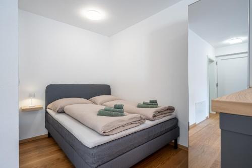 a bedroom with a bed with white walls at Modernes Studio mit sonniger Dachterrasse in Telfs