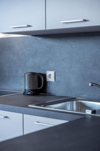 a pot sitting on top of a kitchen sink at Modernes Studio mit sonniger Dachterrasse in Telfs