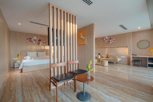 a bedroom with a bed and a living room at Emerald Bay Hotel & Spa Nha Trang in Nha Trang