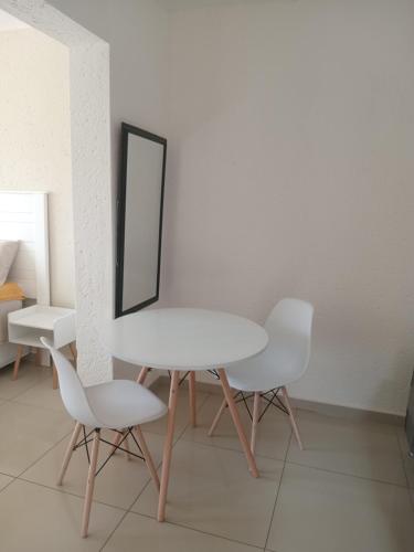 a white table and two white chairs and a mirror at Baksman's Retreat in Soweto