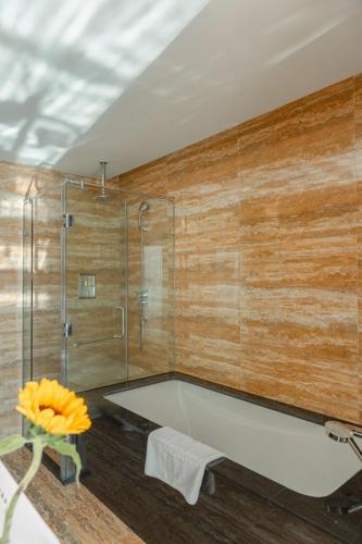 a bathroom with a shower and a bath tub at Emerald Bay Hotel & Spa Nha Trang in Nha Trang
