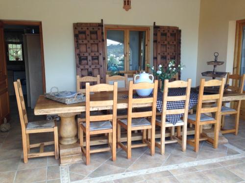 a dining room with a wooden table and chairs at Finca la Jarra in Benitachell