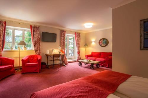 a bedroom with red furniture and red chairs and a bed at Romantik Hotel Friederikenhof Hotel Restaurant & Spa in Lübeck