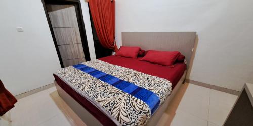 a bedroom with a bed with red pillows on it at Villa Zam Zam Puncak in Puncak