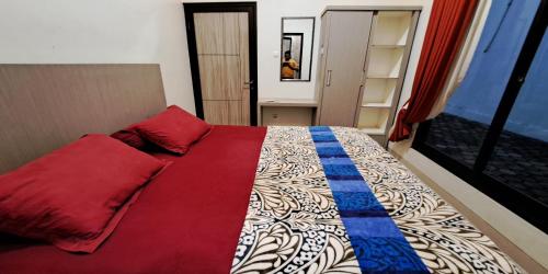 a bedroom with a bed with red and blue pillows at Villa Zam Zam Puncak in Puncak
