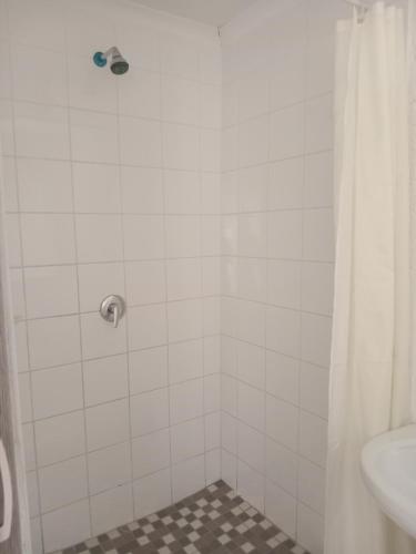 a bathroom with a shower with a toilet and a sink at Baksman's Retreat in Soweto