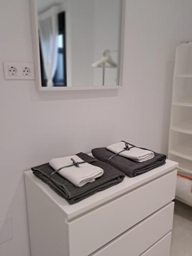 a bathroom with two towels on top of a dresser at AM Chinorros Square. in Fuengirola