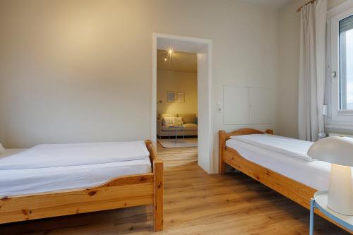 two beds in a room with a mirror at homie stay Süßenmühle - Apartments am Bodensee in Sipplingen