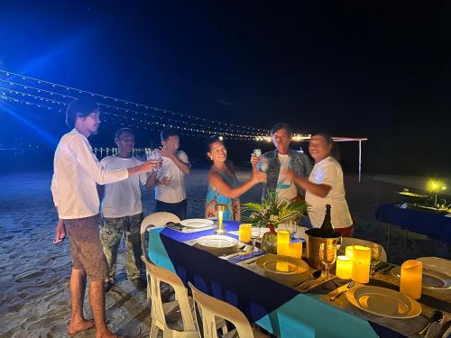 a group of people drinking wine at a table on the beach at Puerto Silanguin Beach Resort in Subic