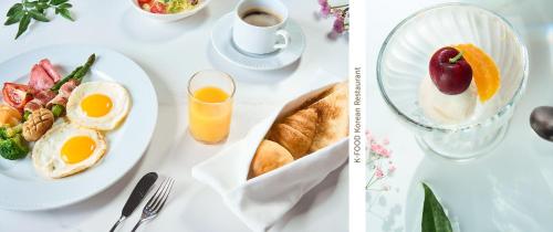 a table with plates of breakfast food and a glass of orange juice at Eliena Hotel Seoul Gangnam in Seoul