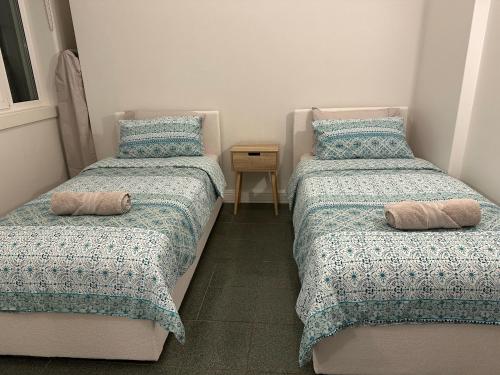 two beds with pillows in a small bedroom at Cliveden on Bridge in Sydney