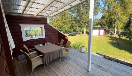 a patio with a table and chairs on a deck at B & B Hjärthuset Zweden Ekshärad in Ekshärad