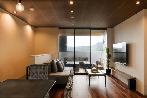 a living room with a couch and a table at MIRATIO Sauna Onna in Onna