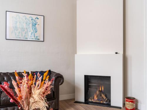 a living room with a couch and a fireplace at Huis Dries in Borgloon