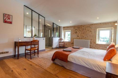 une chambre avec un lit, un bureau et une table dans l'établissement Château Caillivet au cœur d'un vignoble Bio pour 2 à 6 personnes, à Mazères