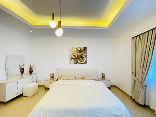 a bedroom with a large white bed and a window at Al Hamra Residence in Ras al Khaimah