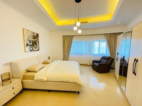 a bedroom with a bed and a chair in it at Al Hamra Residence in Ras al Khaimah